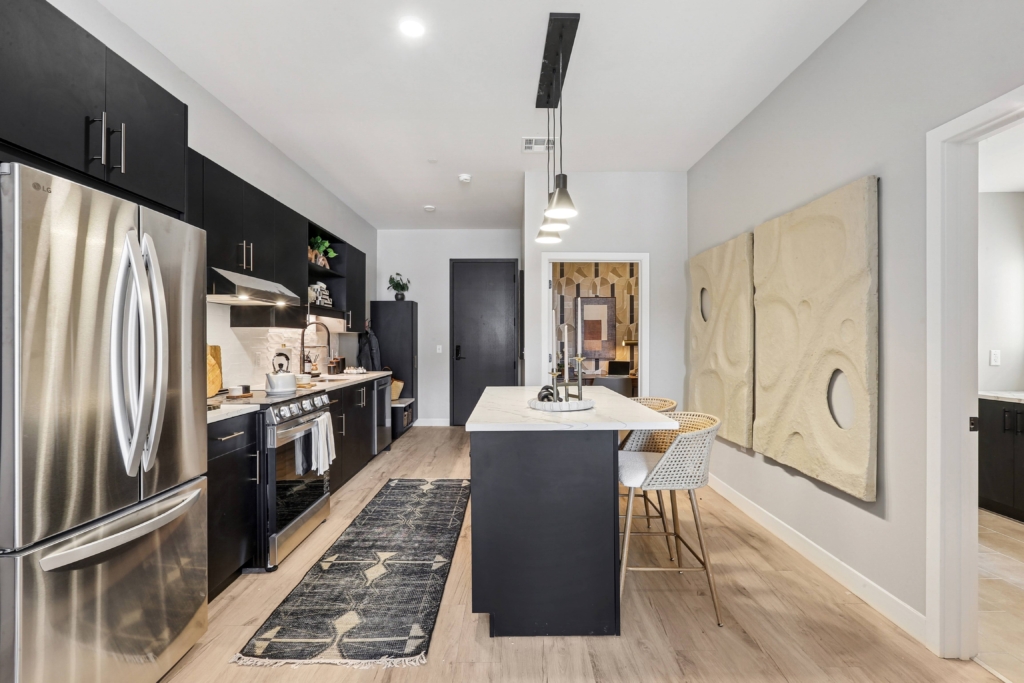 Kitchen island with black cabinetry and pendant lighting